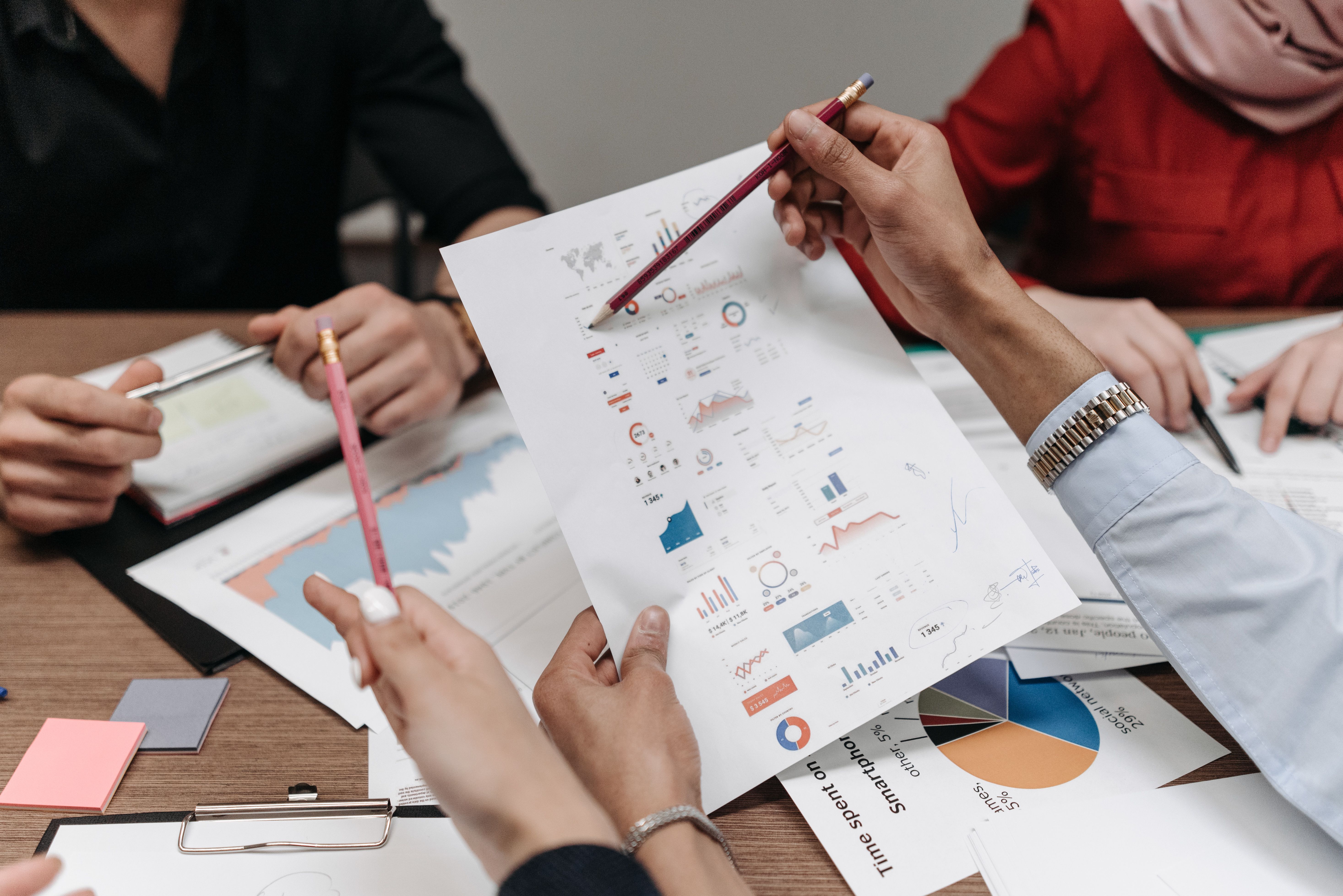 Professionals analyzing business reports and charts during a collaborative meeting, illustrating financial transparency.